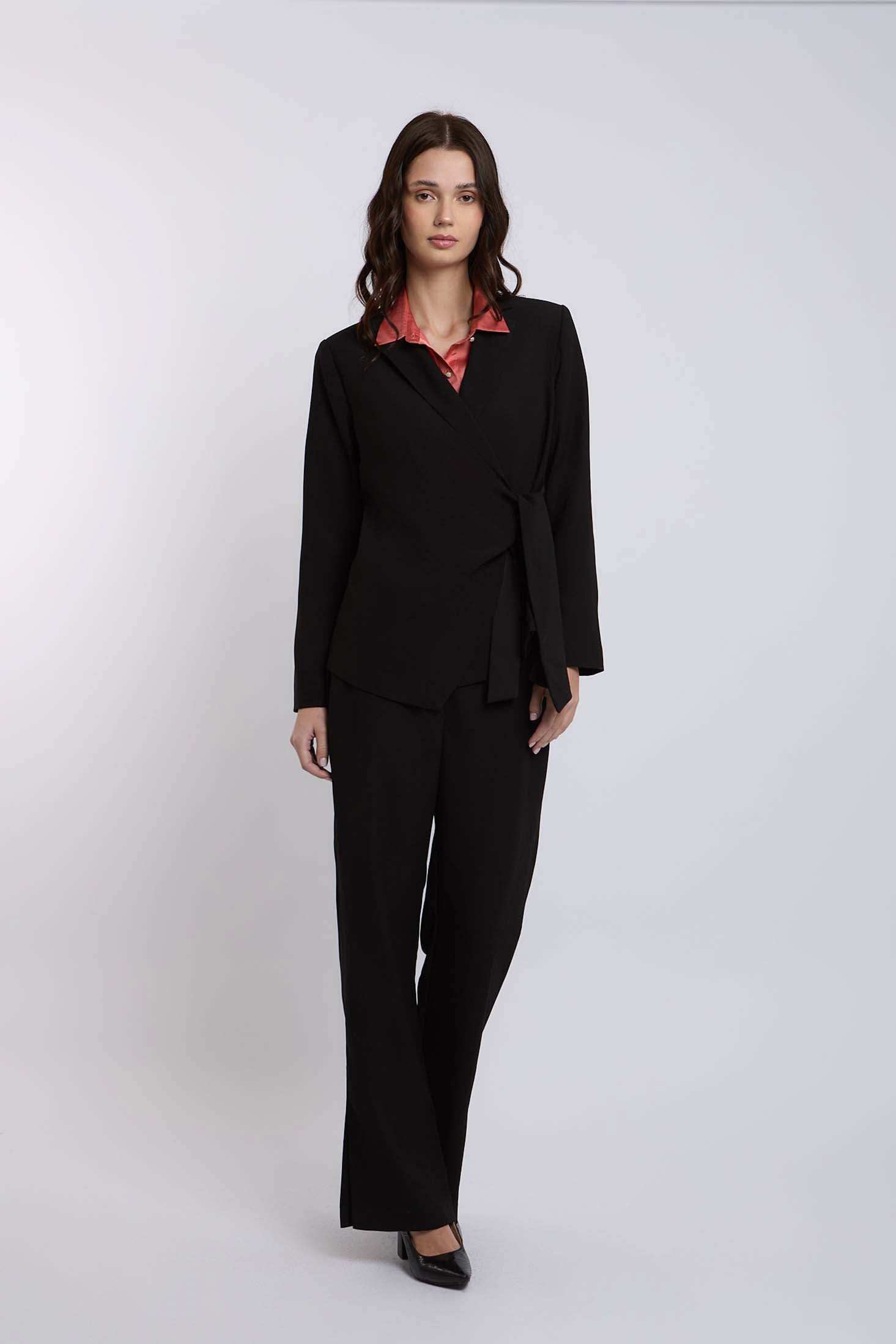 Woman wearing black tailored suit with wide-leg pants and a pink collared blouse