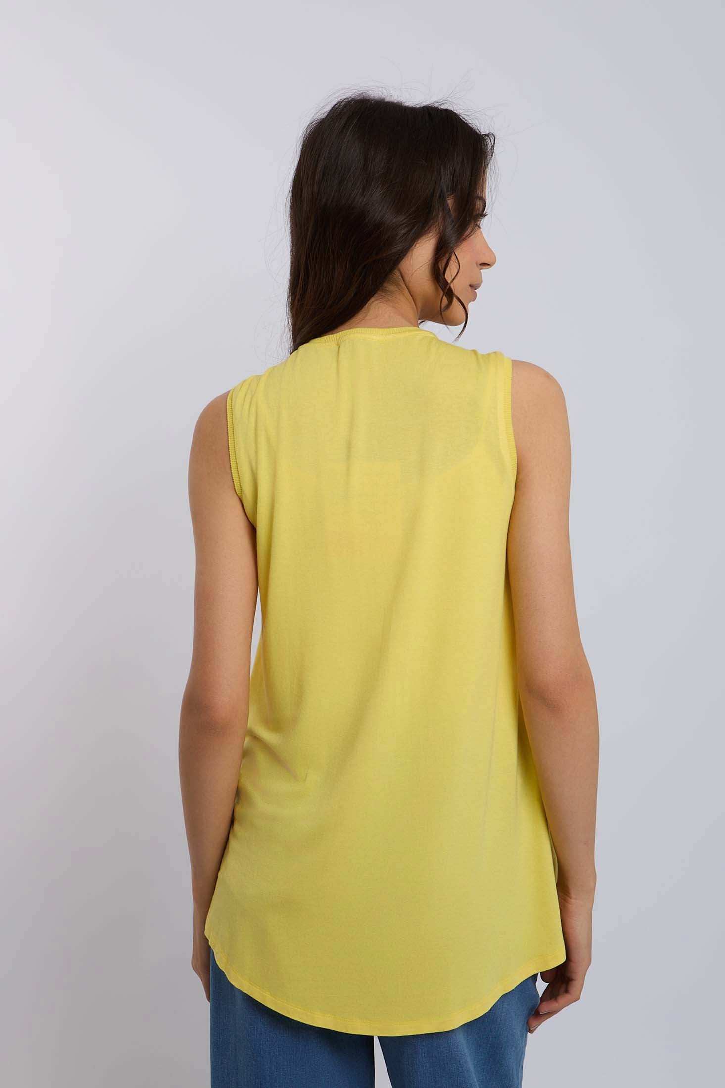 Woman wearing sleeveless yellow top and blue jeans, back view, casual fashion