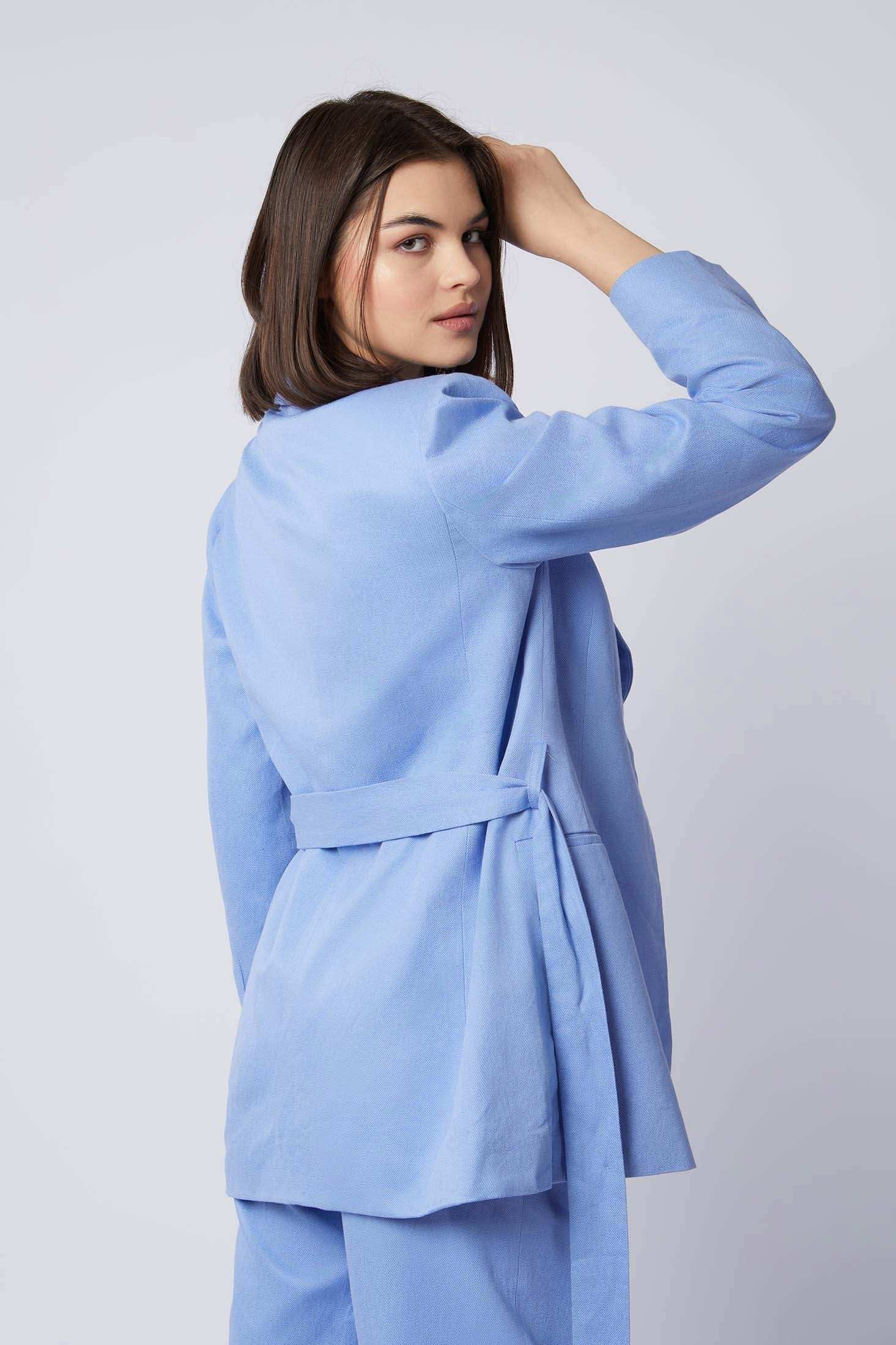 Woman in light blue belted blazer and pants set, back view, casual fashion look